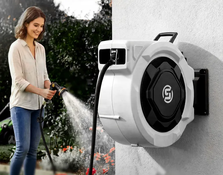 A woman waters a flower bed from a white wall-mounted SUNPOW hose reel